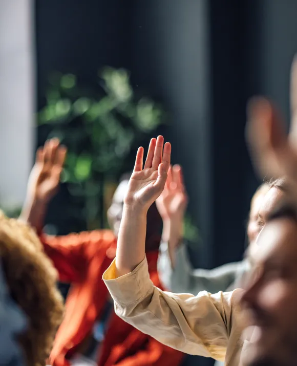 Hands are raised at a meeting