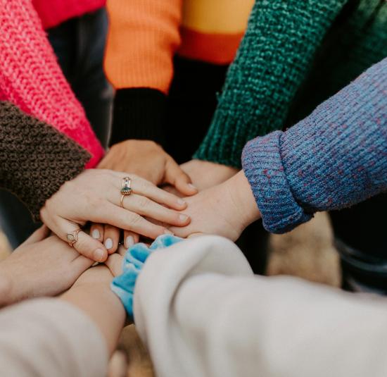 A group of people placing their hands in a circle all together